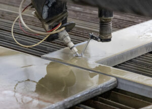 5-axis waterjet bevel cutting examples, including tapered and angled edges, precision holes, and clean cuts on metal parts.